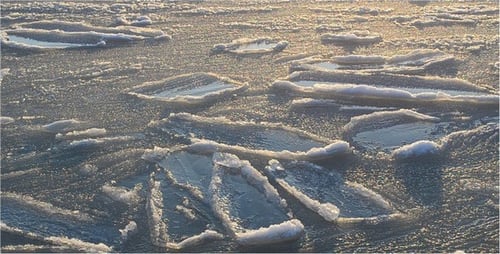 Icy Water Reflects Golden Sunlight at Sunset