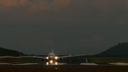 Passenger Airplane Taxiing on Wet Runway in Low Light