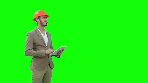 Engineer in Safety Helmet Conducting Inspection with Tablet on a Green Screen, Chroma Key