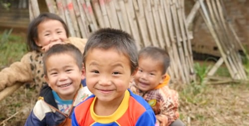 Cheerful Children Smiling Near Bamboo Structure