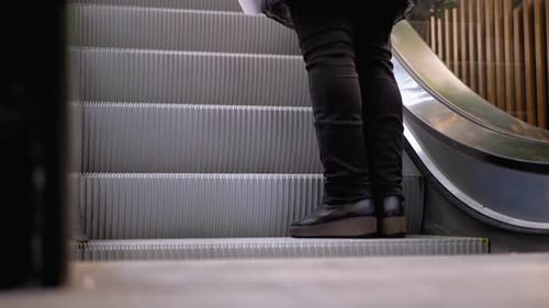 Legs of People Moving on an Escalator Lift in the Mall. Shopper's Feet on Escalator in Shopping