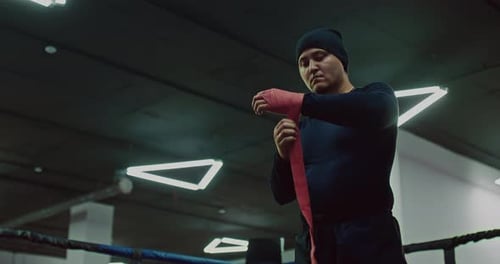 Man Prepares for Boxing Match in Gym