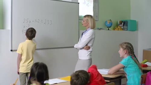Teacher Explaining Math to Students in Classroom