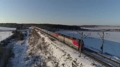 Freight train travels by rail from far away and approaches the camera. Aerial 13