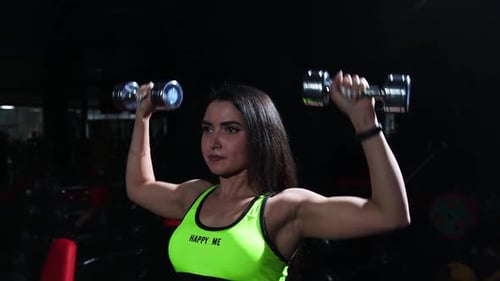 Gym Training Sportive Woman in Yellow Top Lifting Dumbbells and Training Her Hands
