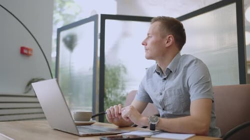 Young Thoughtful Business Man Thinking of Problem Solution Working on Laptop