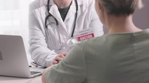 Female Doctor Talking to Woman Patient During Medical Appointment Clinic Office