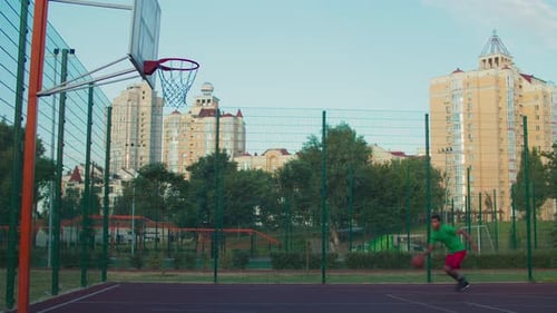 Basketball Player Dribbling and Shooting on Outdoor Court