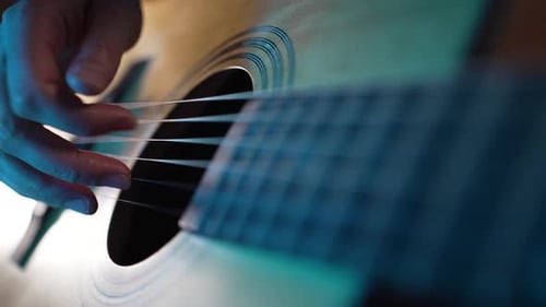 Hand of Man Touching Strings of Guitar Performing on Stage