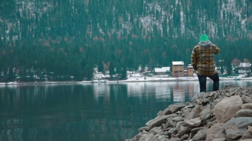 Man Stands On The Shore Of The Lake