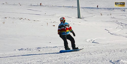 Snowboarder Riding Down Snowy Mountain Slope