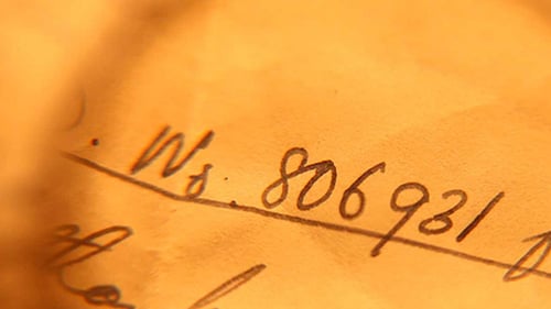 Close Up Handwriting on Paper with Magnifying Glass