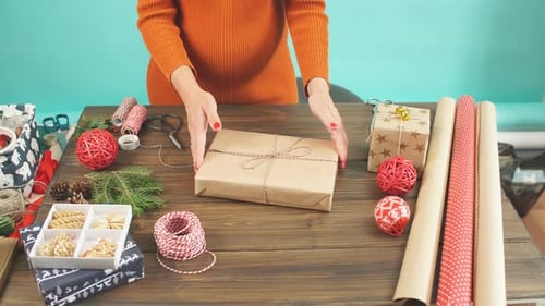 Close up Female hands decorating gift red boxes for Christmas Holiday.