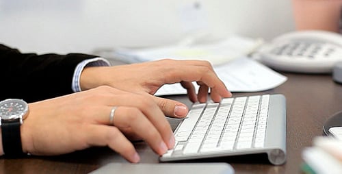 Typing on a Computer Keyboard at Desk