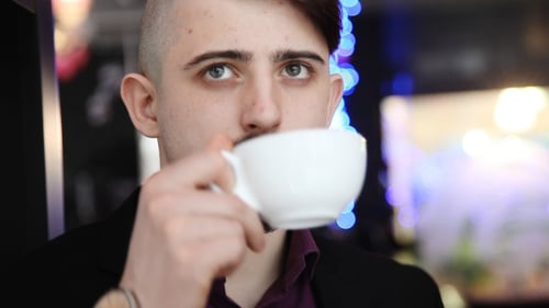 Young Adult Man Drinking Coffee Near Window