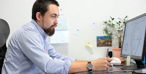 Bearded Artist Illustrates on a Tablet in an Office