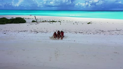 Sexy beauty models on photoshoot having fun on the beach on paradise white sand and blue background