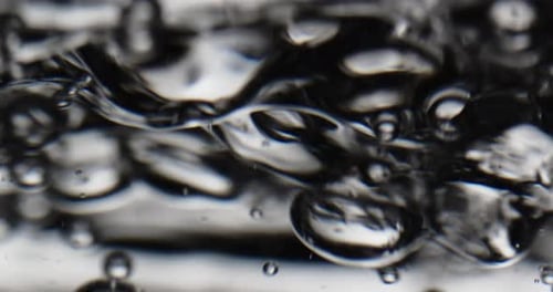 Blasen auf einer sich bewegenden Wasseroberfläche vor weißem Hintergrund
