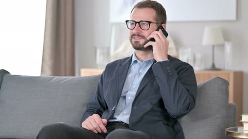 Man Talking on Phone Sitting on Couch