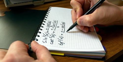 Writing Math Equations in Notebook with Black Pen