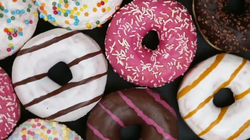 Aerial View of Colorful Donuts on Dark Surface