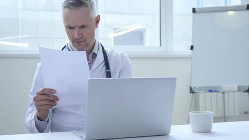 Doctor Reading Medical Report of Patient in Clinic