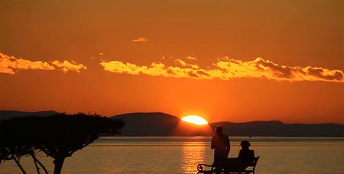Couple Watching Romantic Sunset on the Ocean
