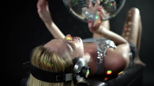 Woman Lying Under Disco Ball with Headphones On