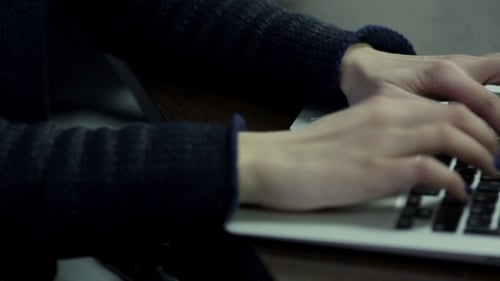 Frauenhand tippt auf Laptoptastatur