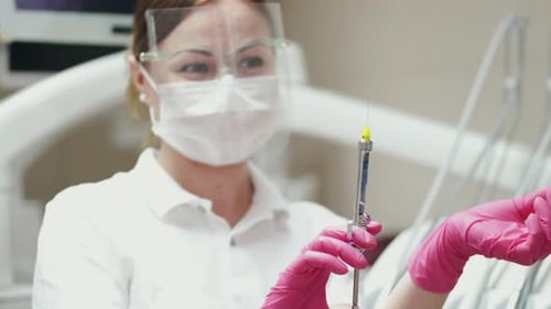 Dentist Prepares Anesthesia Syringe for Procedure