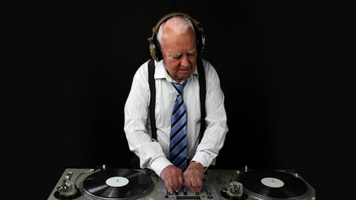 Senior DJ Mixing Music on Turntables