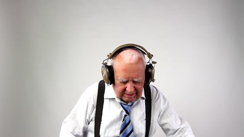 Senior Man Mixing Music on a Soundboard