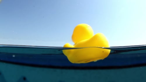 Pato de plástico amarelo flutuando em uma piscina 1