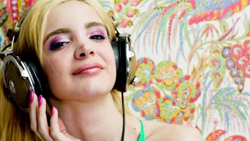 Woman Wearing Headphones Posing With A Colorful Background