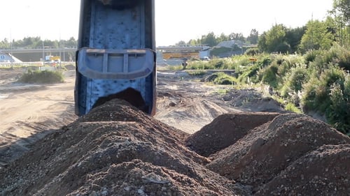 Soil and gravel are dumped by a Truck roadworks