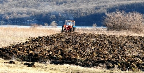 Tractor Tilling Soil in Rural Field