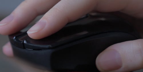 Hand Clicks Black Computer Mouse in Close Up