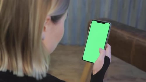 A Young Athletic Woman Holds A Smartphone in Her Hand, Shows A Green Chromakey Screen