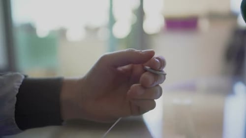 Man's hand nervously tossing euro coin in fingers trying to make right decision