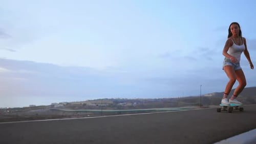 The Girl Is Engaged in Sports Skateboarding with Mountain