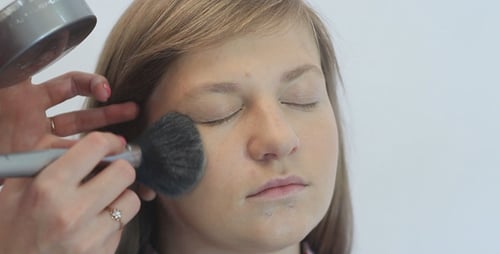 Applying Makeup With a Brush to a Face