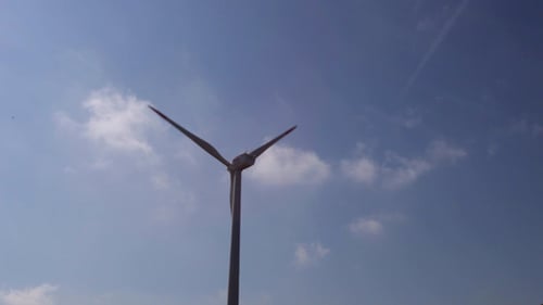 Wind Turbine Spinning Under Blue Sky