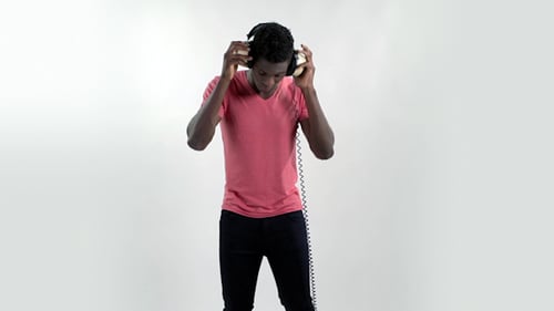 Young Adult Dancing with Headphones in Bright Studio