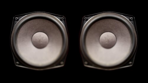 Speakers Vibrating Rapidly Against Black Background