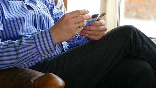 Person Reviewing Stack of Credit Cards Indoors