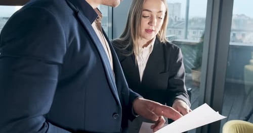 Man and a Woman Discussing Work in the Brightly Lit Modern Office. Concerned Male and Female Working