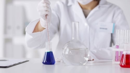 Scientist Conducts Experiment in Laboratory with Pipette