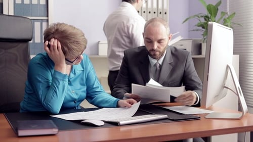 Businesspeople Reviewing Documents at Office Desk