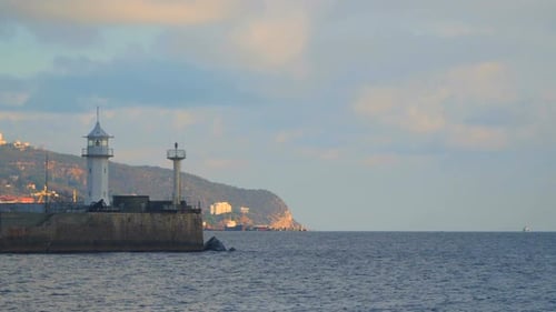 Lighthouse On the Pier In the Background Of Mountains