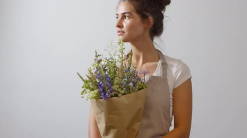 Fleuriste brune posant avec un bouquet de fleurs sauvages